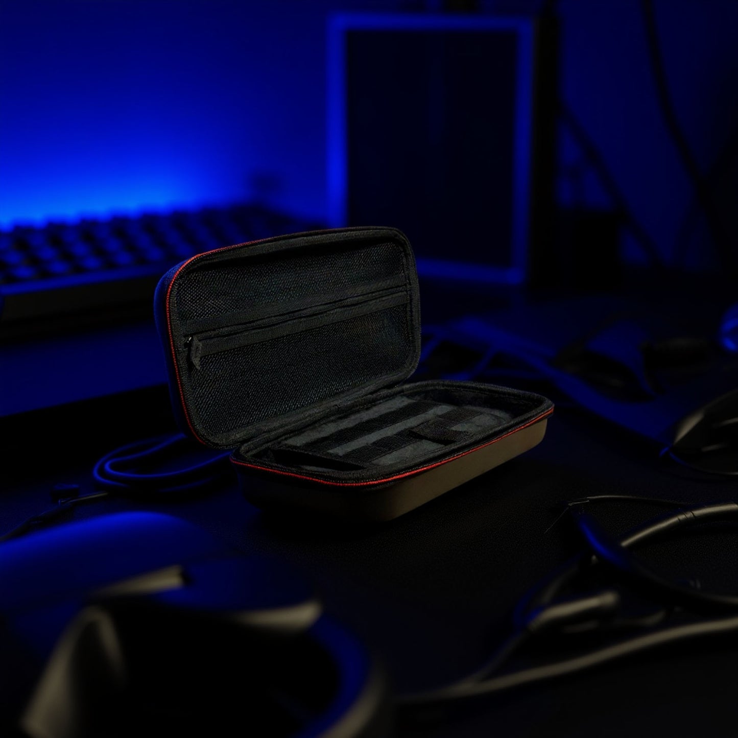 Open Nintendo Switch 2 black and red hard shell travel case displayed on a dark gaming desk with blue LED background lighting.